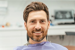 Bearded man in dental chair smiling